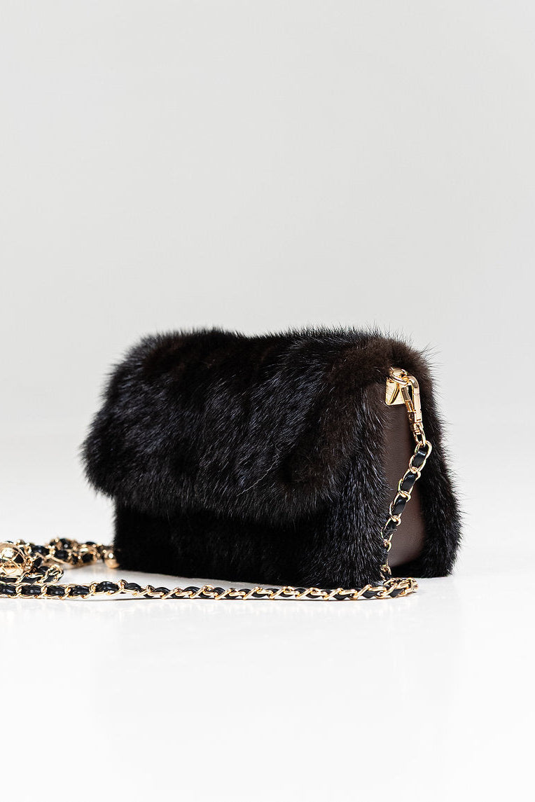 A small brown fur shoulder bag with a gold-tone chain strap, displayed on a clean white studio background.