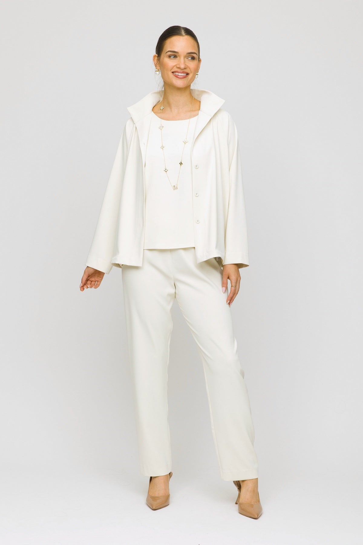 Woman wearing a white outfit on a plain background