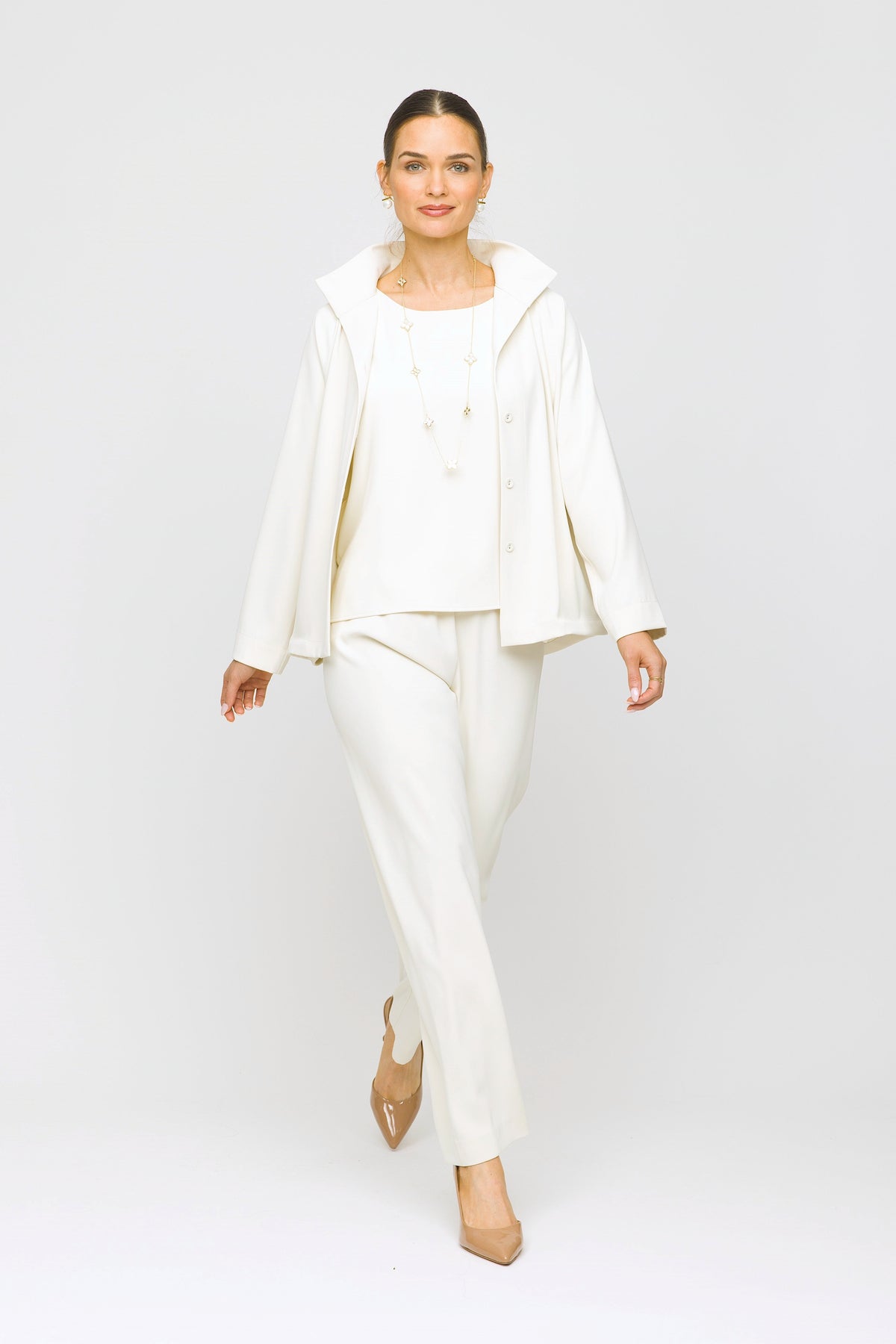 Woman wearing a white outfit on a plain background