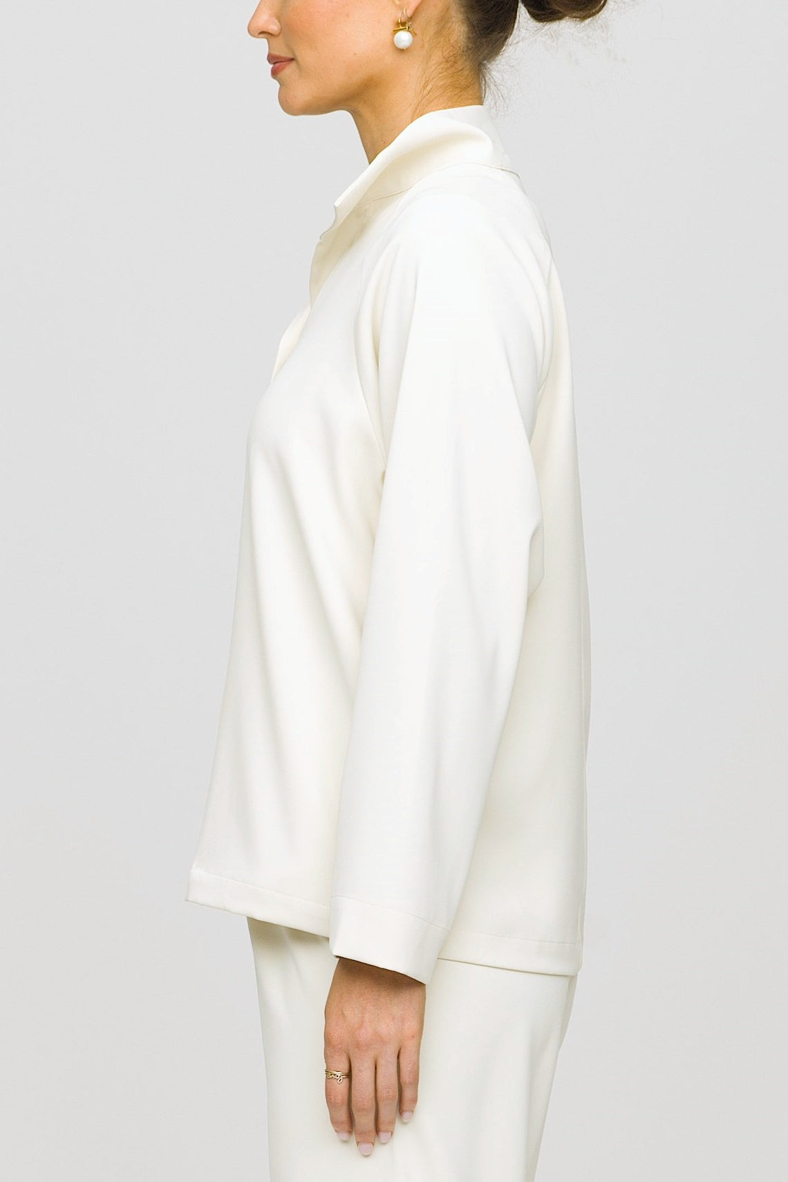 Person wearing a white outfit against a plain background